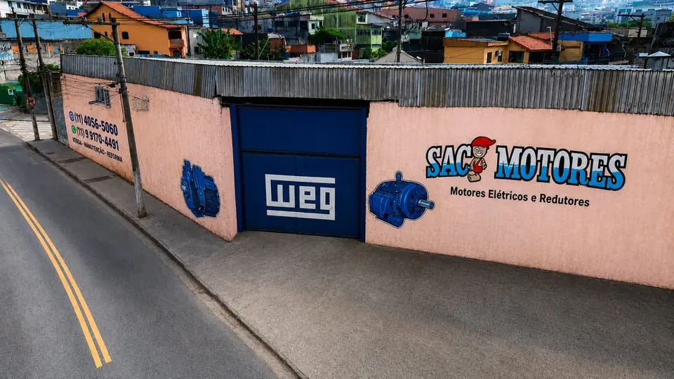 Fachada da Saci Motores Elétricos Usados em Mauá, com portão WEG e motores pintados no muro